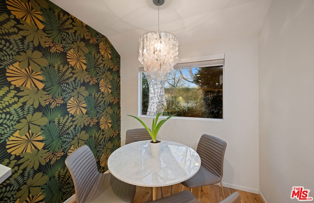 dining space featuring vaulted ceiling, wood-type flooring, and a notable chandelier