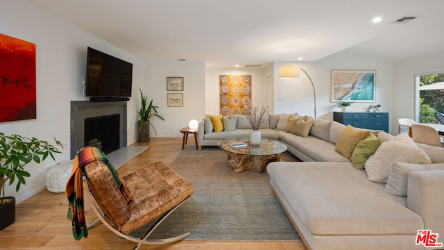 living room featuring lofted ceiling and light hardwood / wood-style flooring