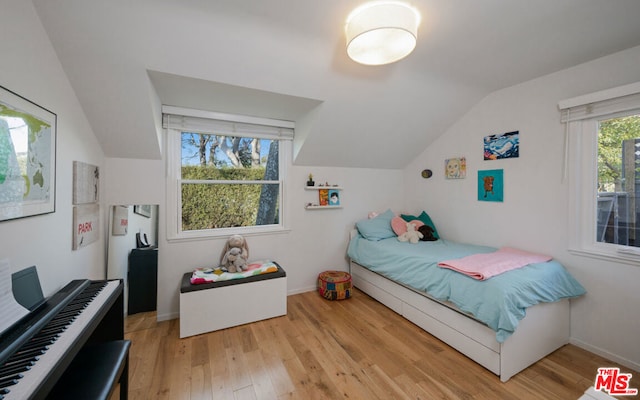 bedroom featuring lofted ceiling and light wood-type flooring