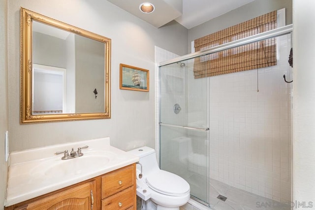 bathroom featuring walk in shower, vanity, and toilet