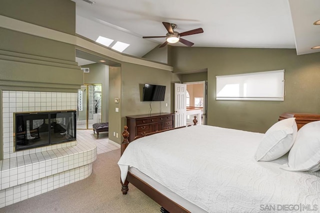 carpeted bedroom featuring ceiling fan, lofted ceiling, and a tile fireplace