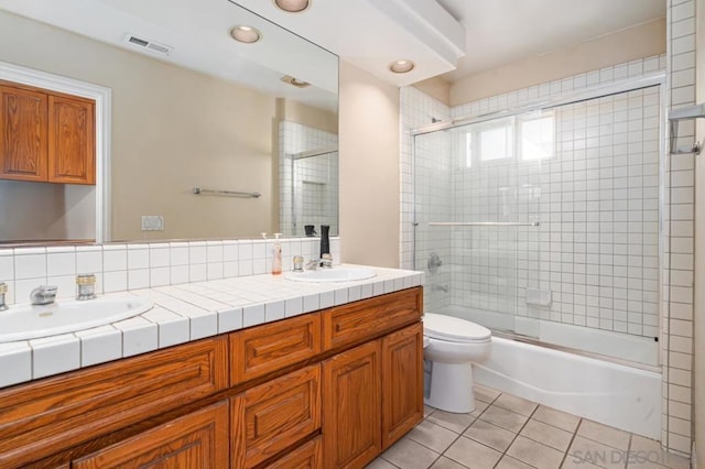 full bathroom featuring enclosed tub / shower combo, vanity, toilet, and tile patterned flooring