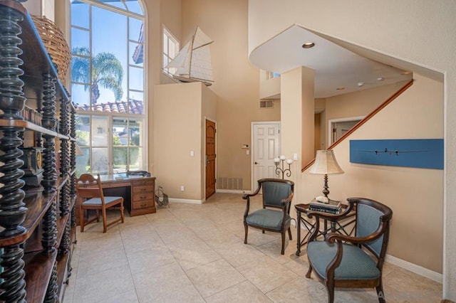 sitting room with light tile patterned flooring and a high ceiling