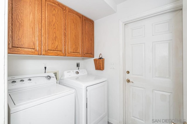 clothes washing area featuring independent washer and dryer and cabinets