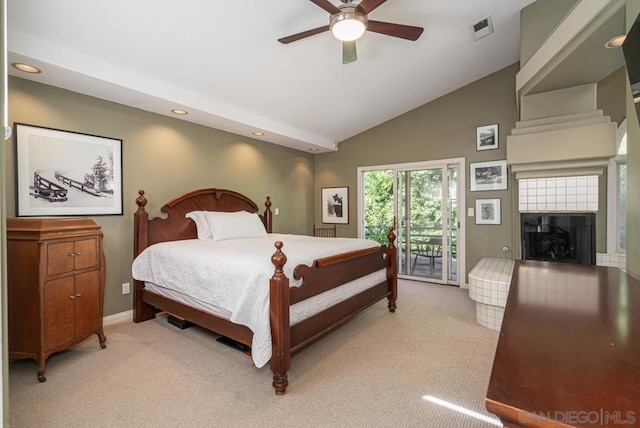 carpeted bedroom featuring ceiling fan, vaulted ceiling, a tile fireplace, and access to outside