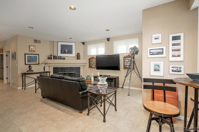 living room with light tile patterned floors and a tile fireplace