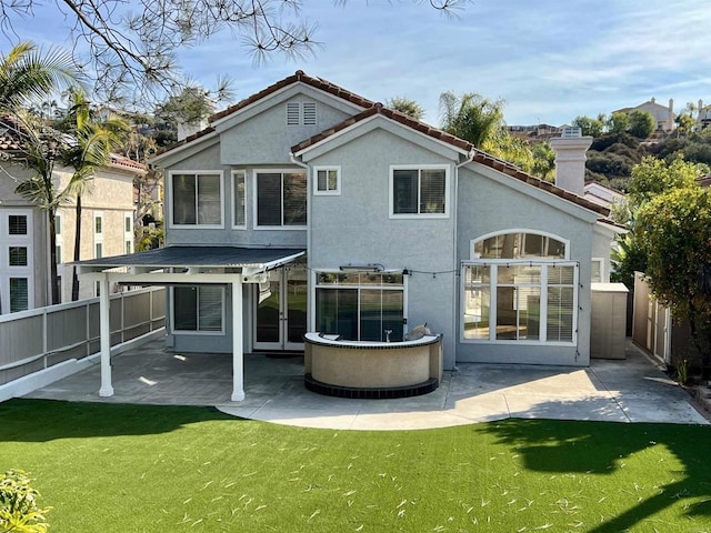 back of house with a patio and a lawn