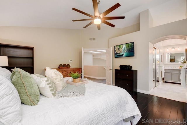 bedroom featuring lofted ceiling, dark wood-type flooring, ceiling fan, and ensuite bathroom