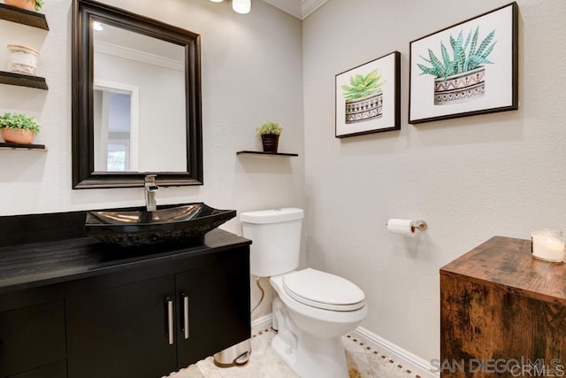 bathroom featuring vanity, ornamental molding, and toilet