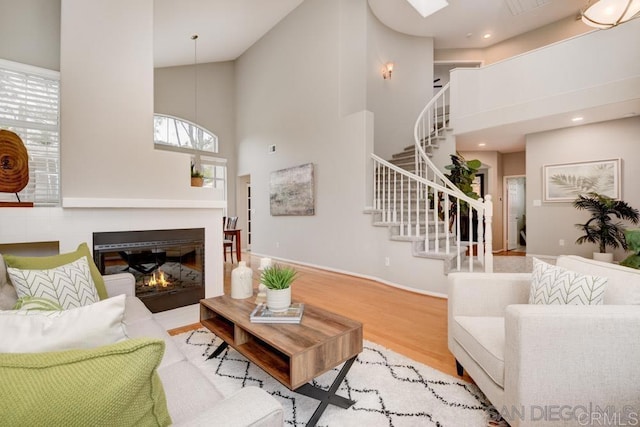 living room with light wood-type flooring and a high ceiling