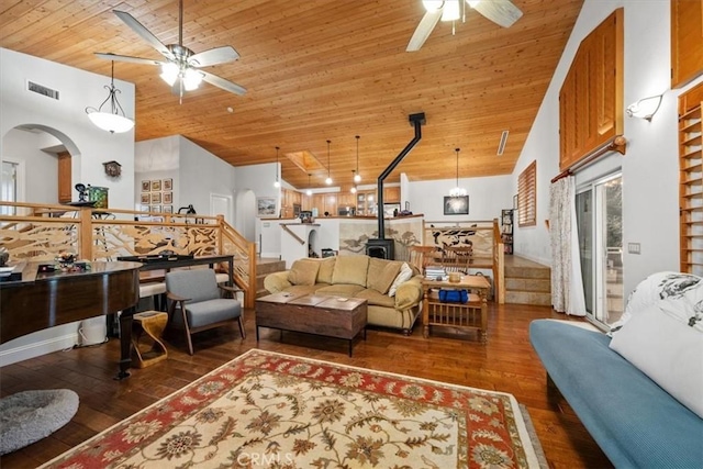 living room featuring wood ceiling, dark wood-type flooring, high vaulted ceiling, and a wood stove