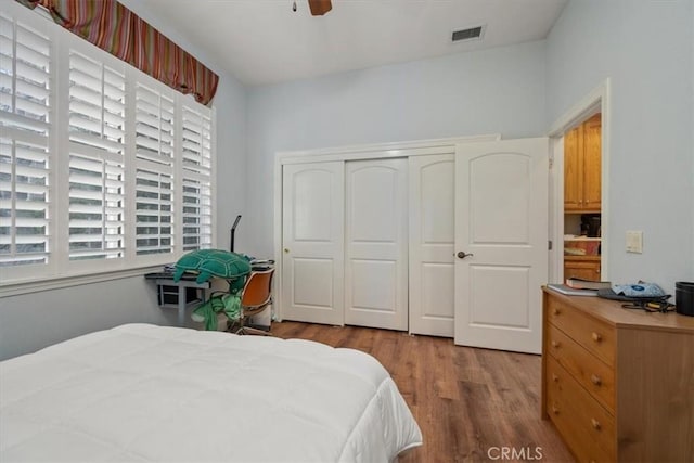 bedroom with ceiling fan, wood-type flooring, and a closet