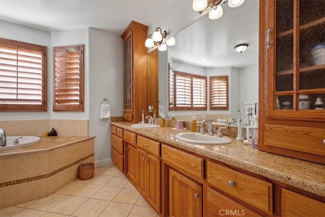 bathroom with a relaxing tiled tub, tile patterned floors, and vanity