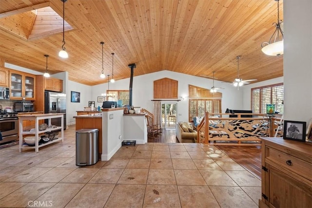 kitchen featuring hanging light fixtures, wood ceiling, vaulted ceiling with skylight, and appliances with stainless steel finishes