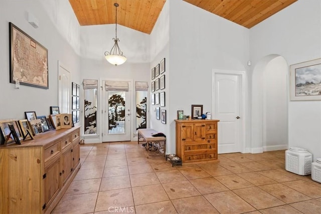 entrance foyer with light tile patterned floors, wood ceiling, and a towering ceiling