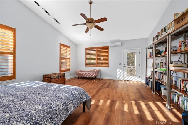 bedroom featuring ceiling fan, access to exterior, a wall unit AC, wood-type flooring, and vaulted ceiling