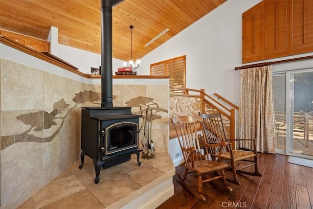 living area featuring hardwood / wood-style flooring, lofted ceiling, a wood stove, and wooden ceiling