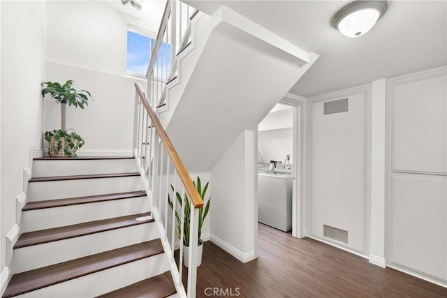 staircase with hardwood / wood-style flooring and washer and clothes dryer