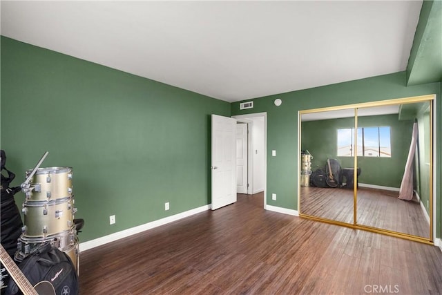 unfurnished bedroom with dark hardwood / wood-style floors and a closet