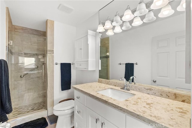 bathroom featuring vanity, an enclosed shower, and toilet