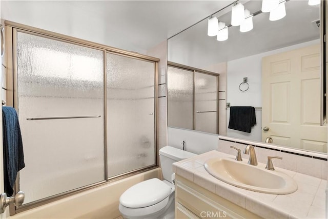 full bathroom with vanity, combined bath / shower with glass door, and toilet