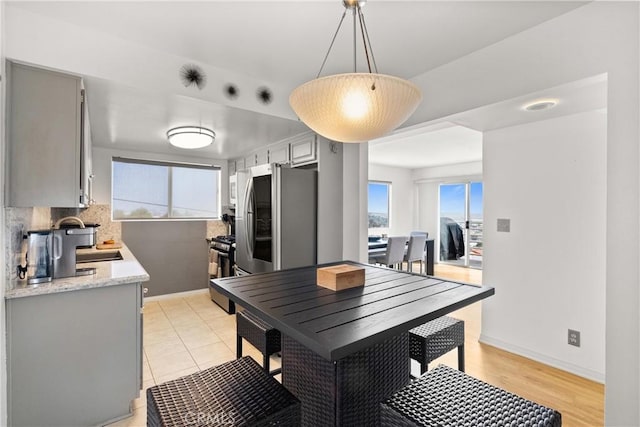 dining space featuring sink and light tile patterned floors