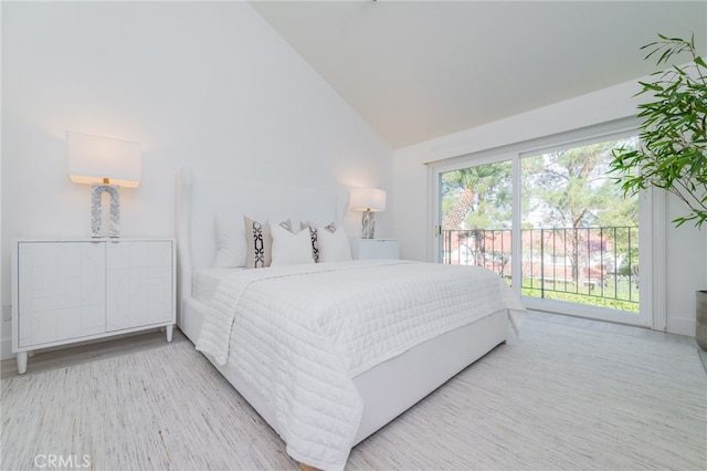 bedroom featuring high vaulted ceiling, light wood-style flooring, and access to exterior