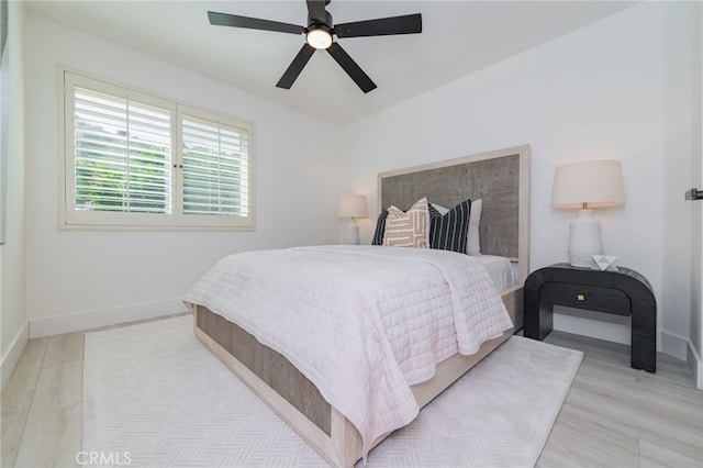 bedroom with a ceiling fan, light wood-type flooring, and baseboards