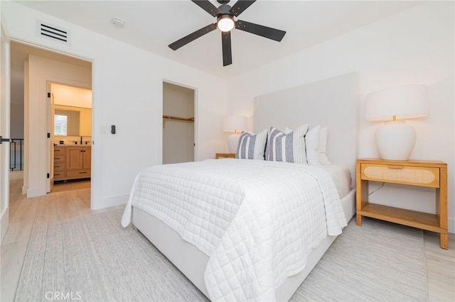 bedroom featuring ceiling fan, wood finished floors, visible vents, baseboards, and a closet