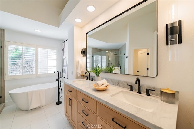 bathroom with double vanity, a freestanding tub, a sink, and a stall shower