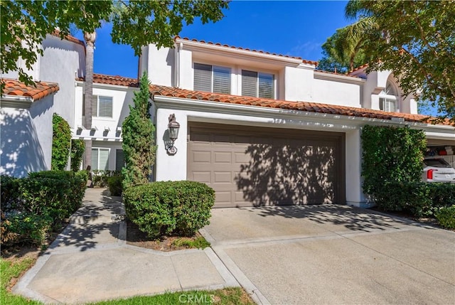 mediterranean / spanish home with a garage, a tile roof, driveway, and stucco siding