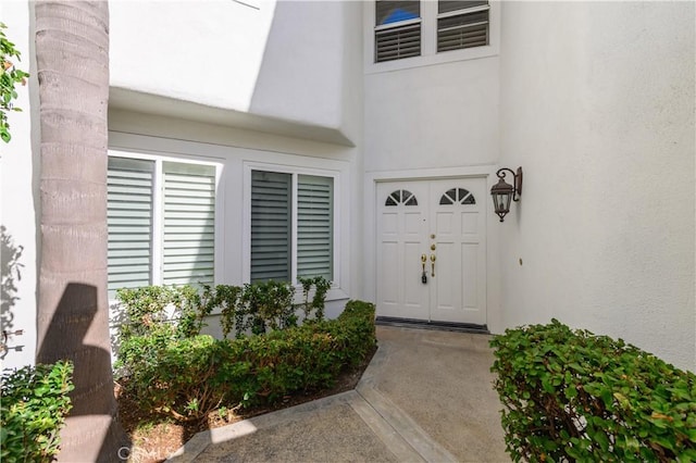 property entrance with visible vents and stucco siding