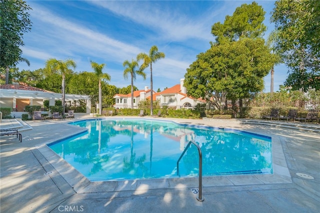 pool featuring a patio and a residential view