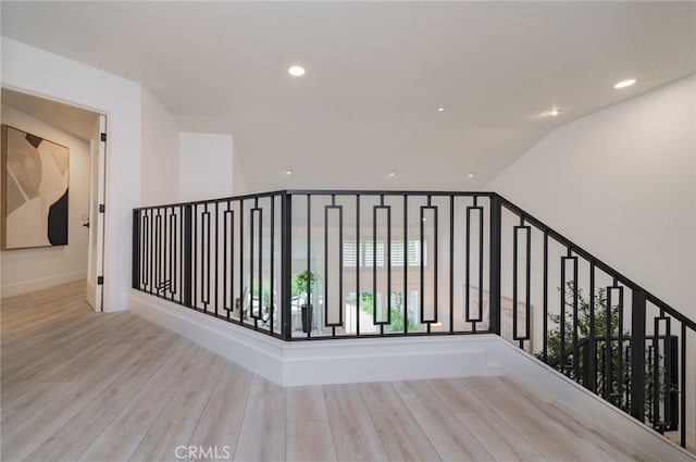 corridor with recessed lighting, vaulted ceiling, baseboards, and wood finished floors