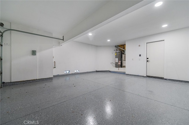 garage featuring recessed lighting and secured water heater