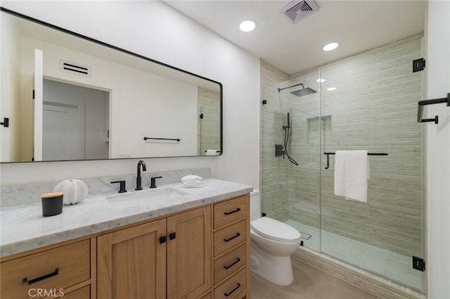 bathroom with toilet, a stall shower, vanity, and visible vents