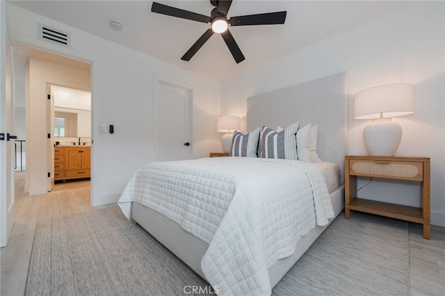 bedroom featuring light wood-style floors, visible vents, ceiling fan, and a sink