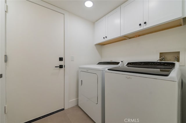 laundry area featuring washing machine and dryer, cabinet space, recessed lighting, and light tile patterned floors