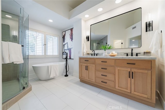 full bathroom with double vanity, a stall shower, and a sink