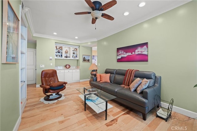 living room with crown molding, ceiling fan, and light wood-type flooring