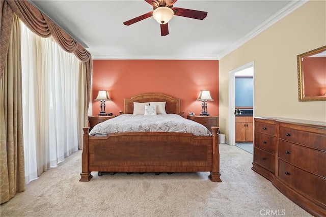 carpeted bedroom with ceiling fan, ornamental molding, and ensuite bathroom