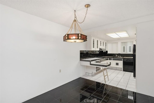 kitchen featuring light tile patterned flooring, pendant lighting, white cabinets, decorative backsplash, and black appliances