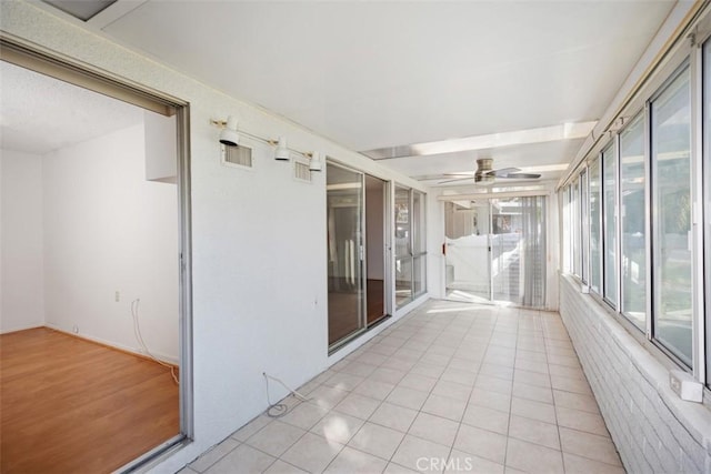 unfurnished sunroom featuring ceiling fan