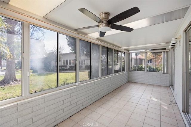 unfurnished sunroom featuring ceiling fan and a wealth of natural light