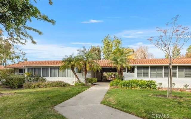 ranch-style house with a carport and a front lawn