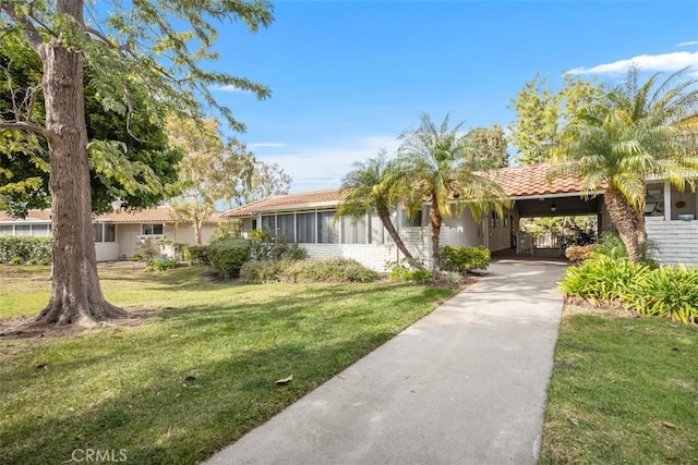 view of front of property featuring a front lawn and a carport