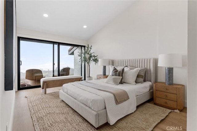 bedroom featuring lofted ceiling and light hardwood / wood-style floors