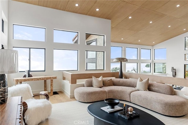 living room featuring a towering ceiling, wooden ceiling, and light hardwood / wood-style floors