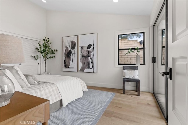 bedroom featuring vaulted ceiling and light wood-type flooring