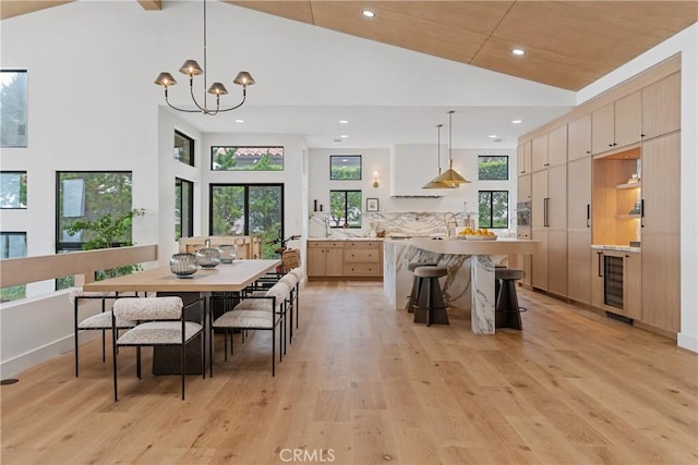 kitchen with hanging light fixtures, a center island, light brown cabinets, and wine cooler